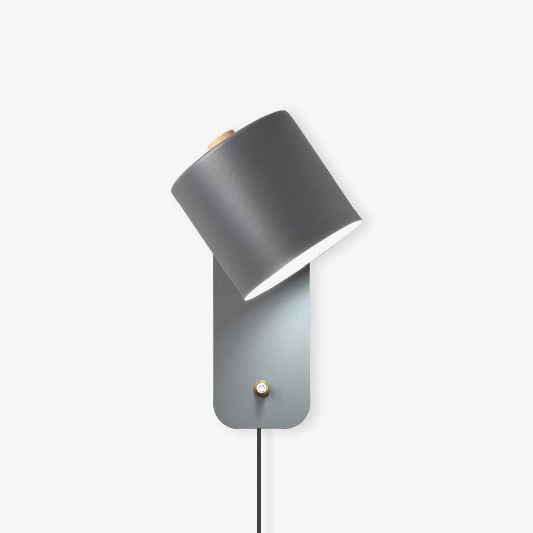 Minimalist metal cylinder wall lamp shown mounted on a wall