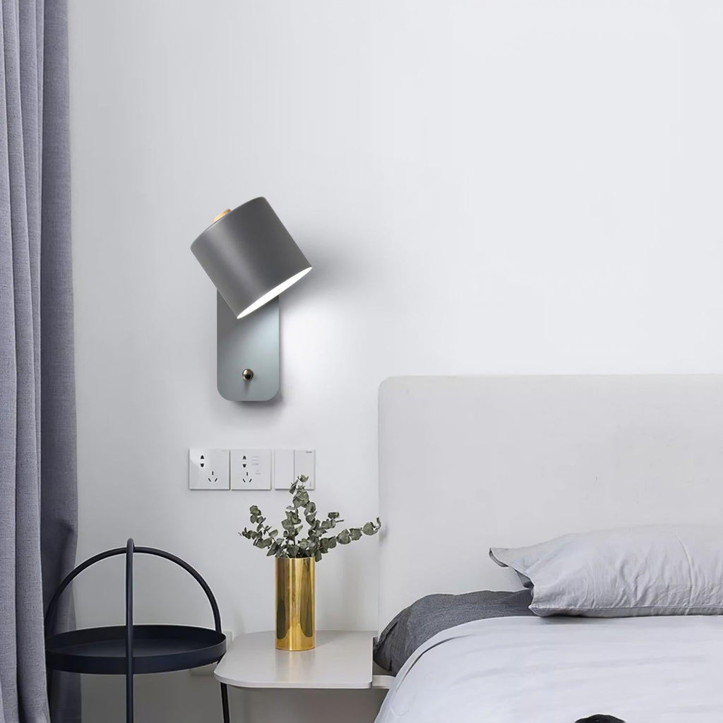 Cylinder wall lamp with rotating shade aimed sideways