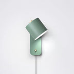 Metal cylinder wall lamp angled to wash light up the wall
