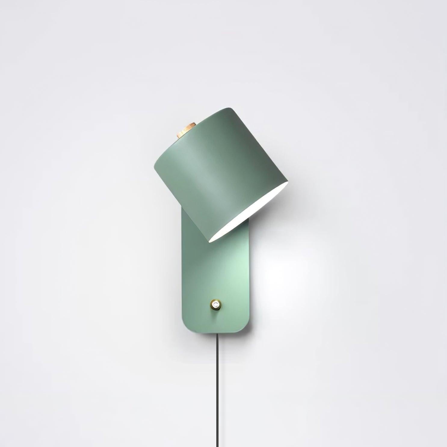 Metal cylinder wall lamp angled to wash light up the wall