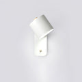 Cylinder wall lamp with rotating shade mounted beside a bed