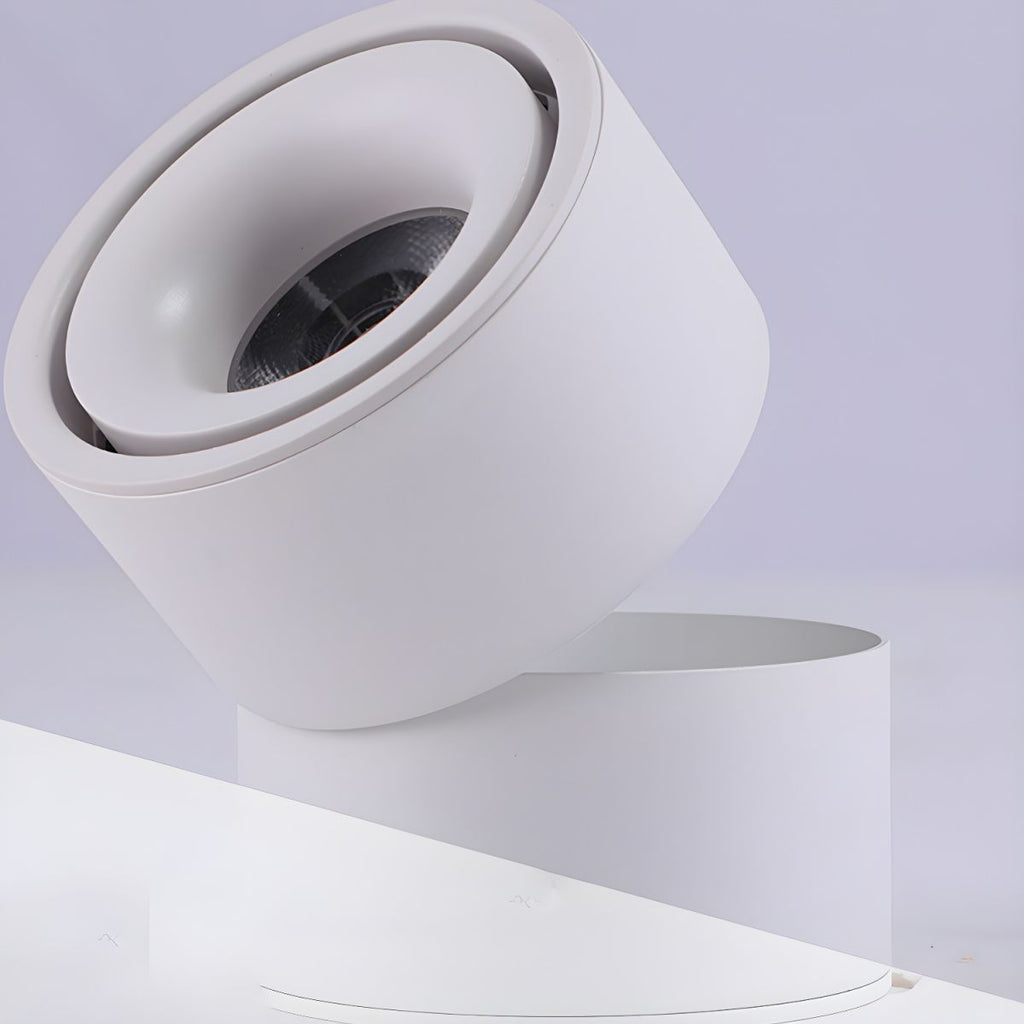 This white Clérachic spotlight is angled to one side against a plain lavender backdrop, unlit.