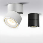 White and black finishes of this Clérachic spotlight are shown together, the white one lit with a gold-rimmed lens.