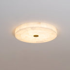 Kristy ceiling lamp lit at an angle, its tall alabaster side band glowing evenly all the way round