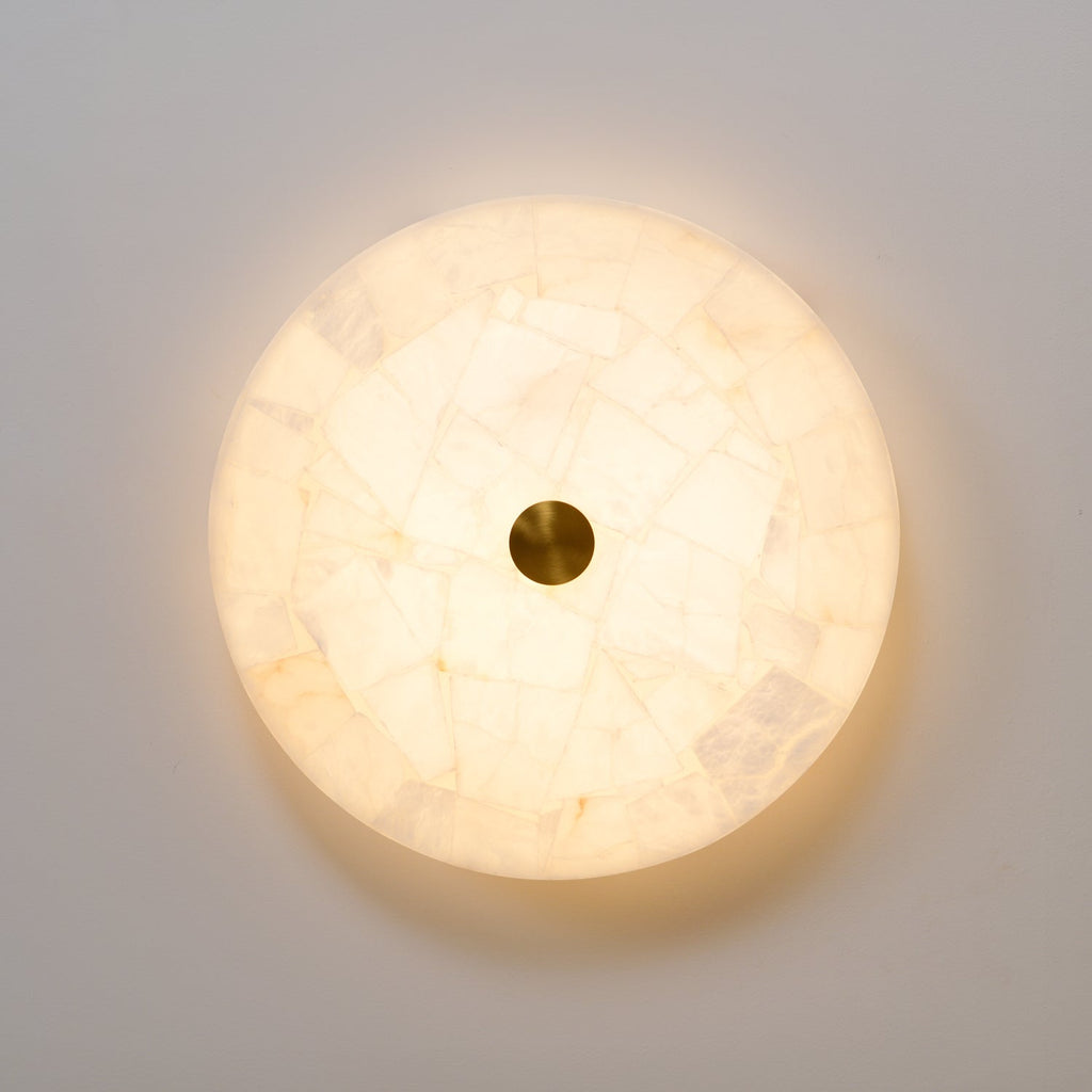 Straight-on view of the pale alabaster face, mosaic tiles glowing evenly around the brass cap