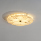 Warm-lit Kristy ceiling lamp with its small brass centre cap and glowing tiled alabaster rim