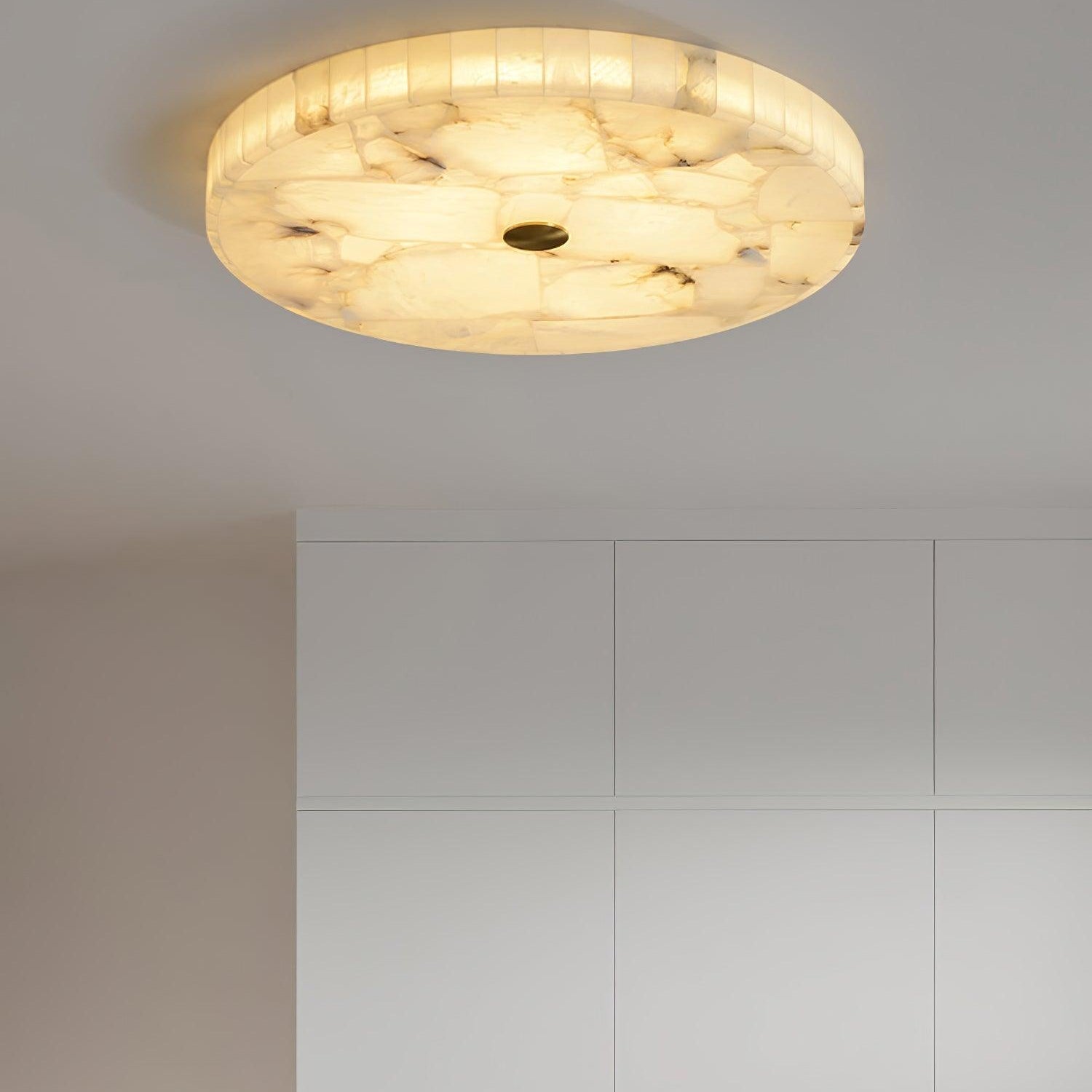Angled view of the flushmount above white wardrobes, its rim tiles catching the light