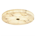 Catalogue view of the round flushmount on a white background, brass cap centred in the stone face