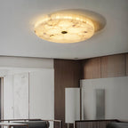 The alabaster flushmount lighting a living room with walnut panelling and low grey sofas