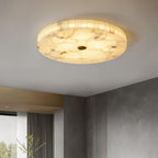 The lit flushmount in a room with a concrete-textured wall and floor-to-ceiling fluted curtains