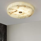 Distant view of the lit flushmount, the room below showing a white wall and dark marble edge