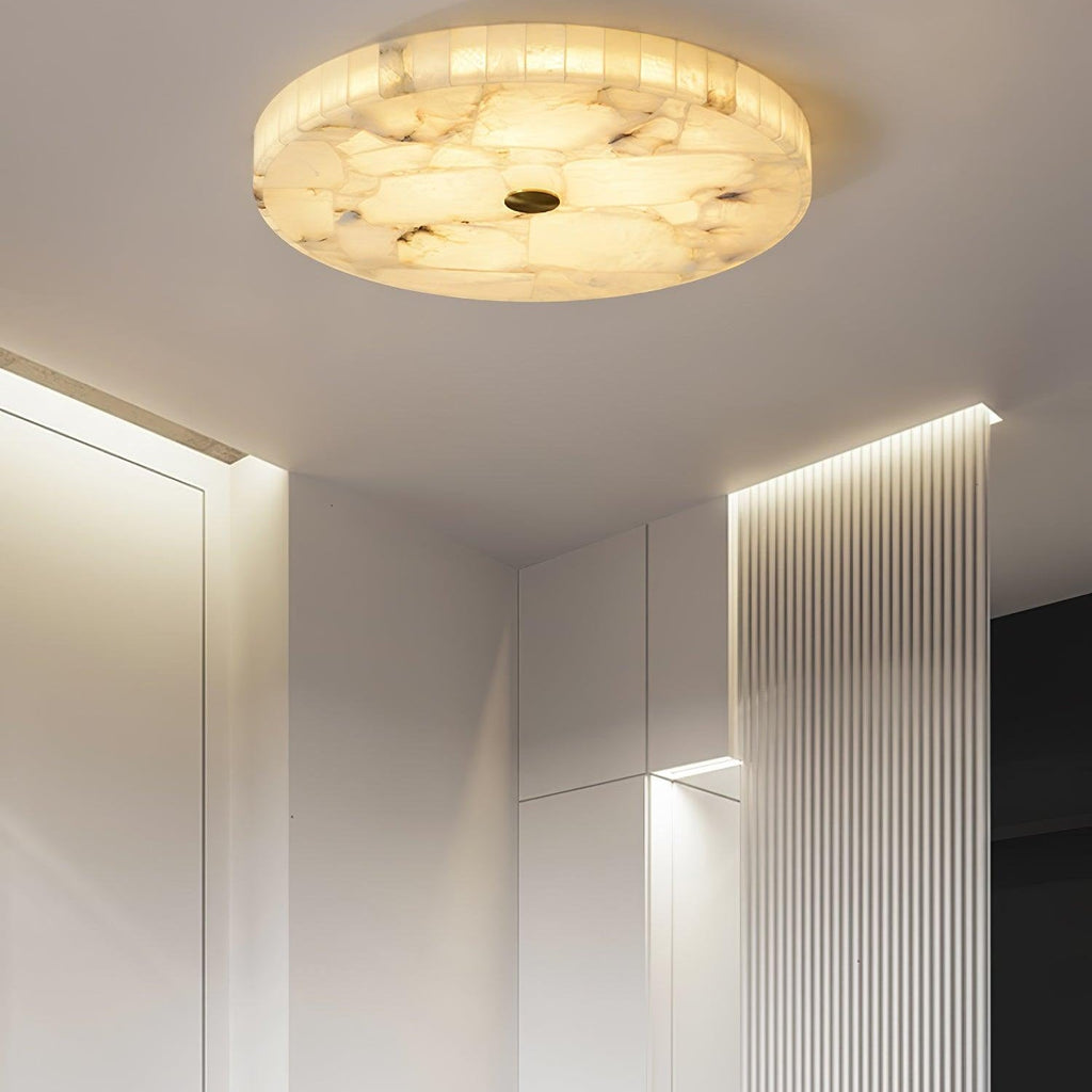 The alabaster flushmount lighting a white entrance hallway beside a fluted, backlit wall panel