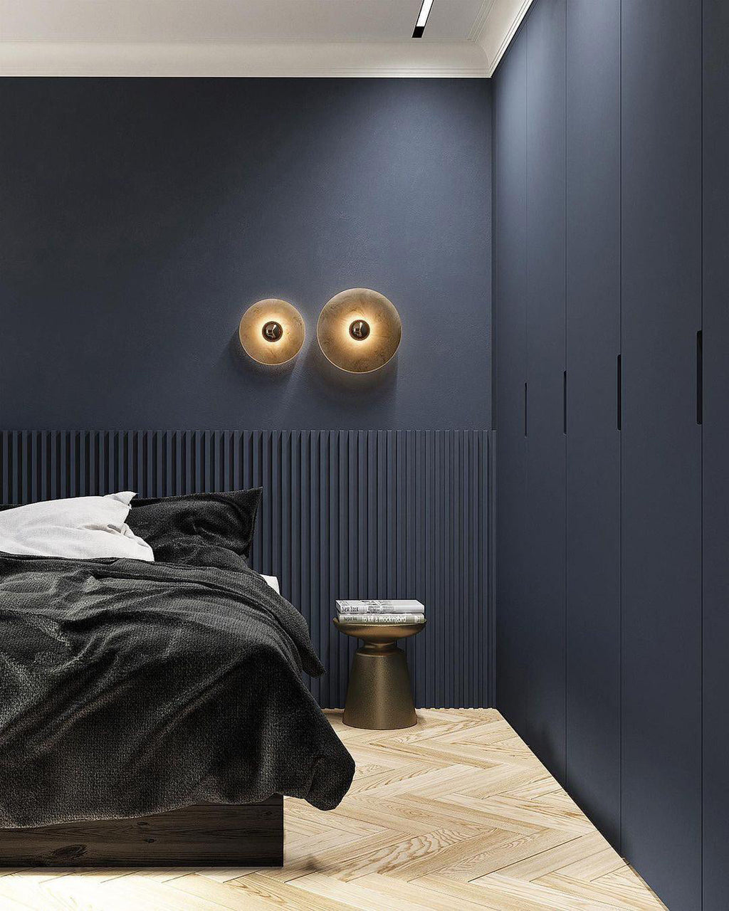 Clérachic wider view of a navy bedroom with a small and a large sconce lit side by side above fluted panelling.