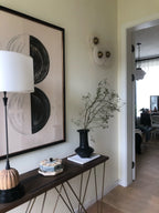 Three Clérachic small sconces clustered on a pale entry wall above a console table with a black vase.