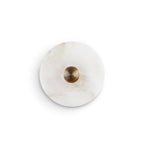 Clérachic three-quarter view of the alabaster sconce with a soft cast shadow, showing how the disc stands off the wall.