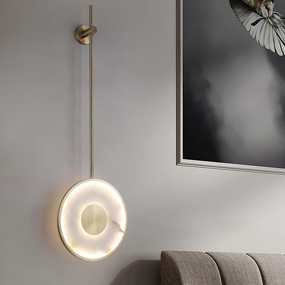 Lit on a pale wall next to a framed photograph of a bird in flight.