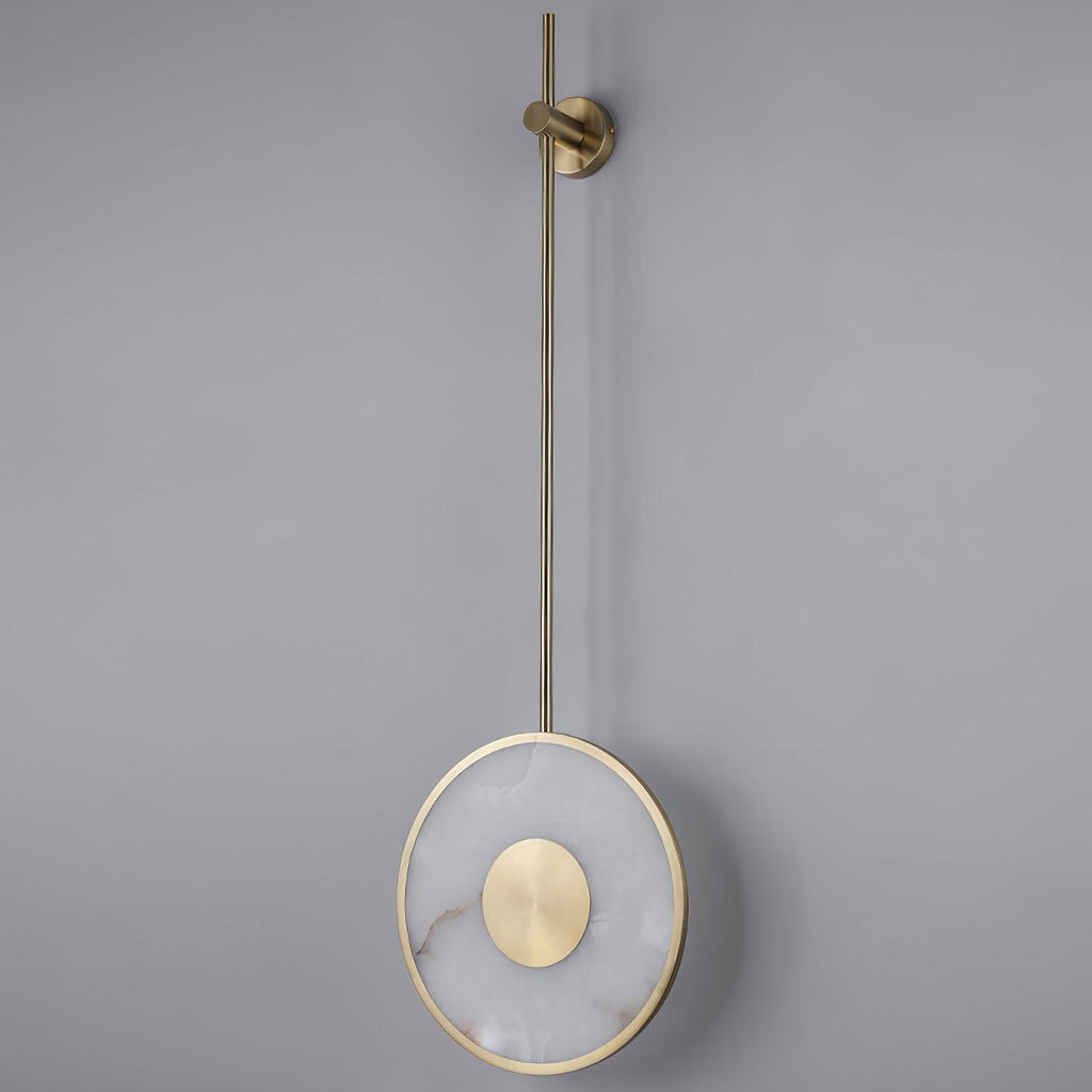 The disc lit on a plain grey wall, warm light haloing out around the alabaster.