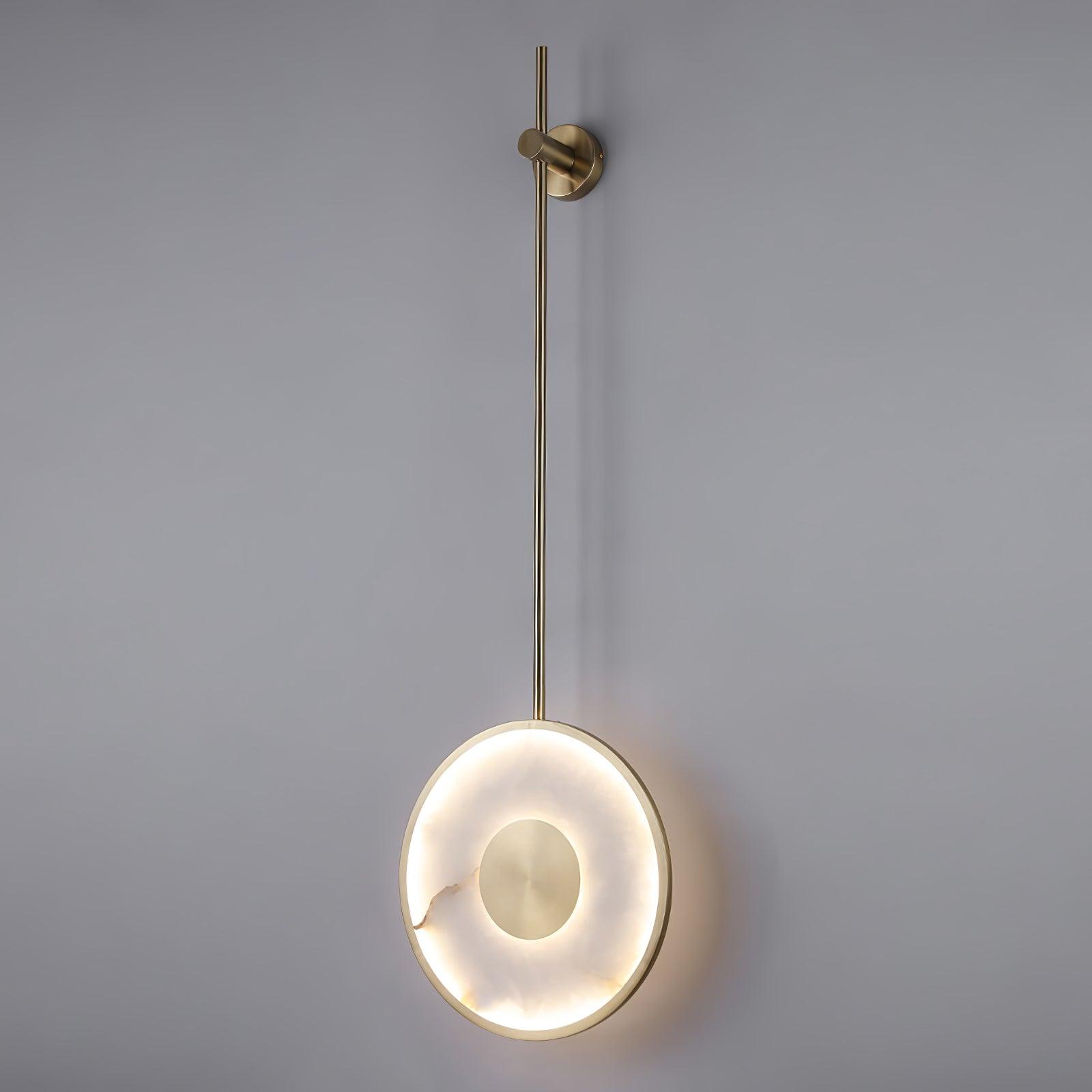 The lit disc on a plain grey wall, seen at full drop from mount to alabaster face.