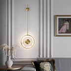 Lit in a classical panelled room beside framed art, pampas grass in a vase below.