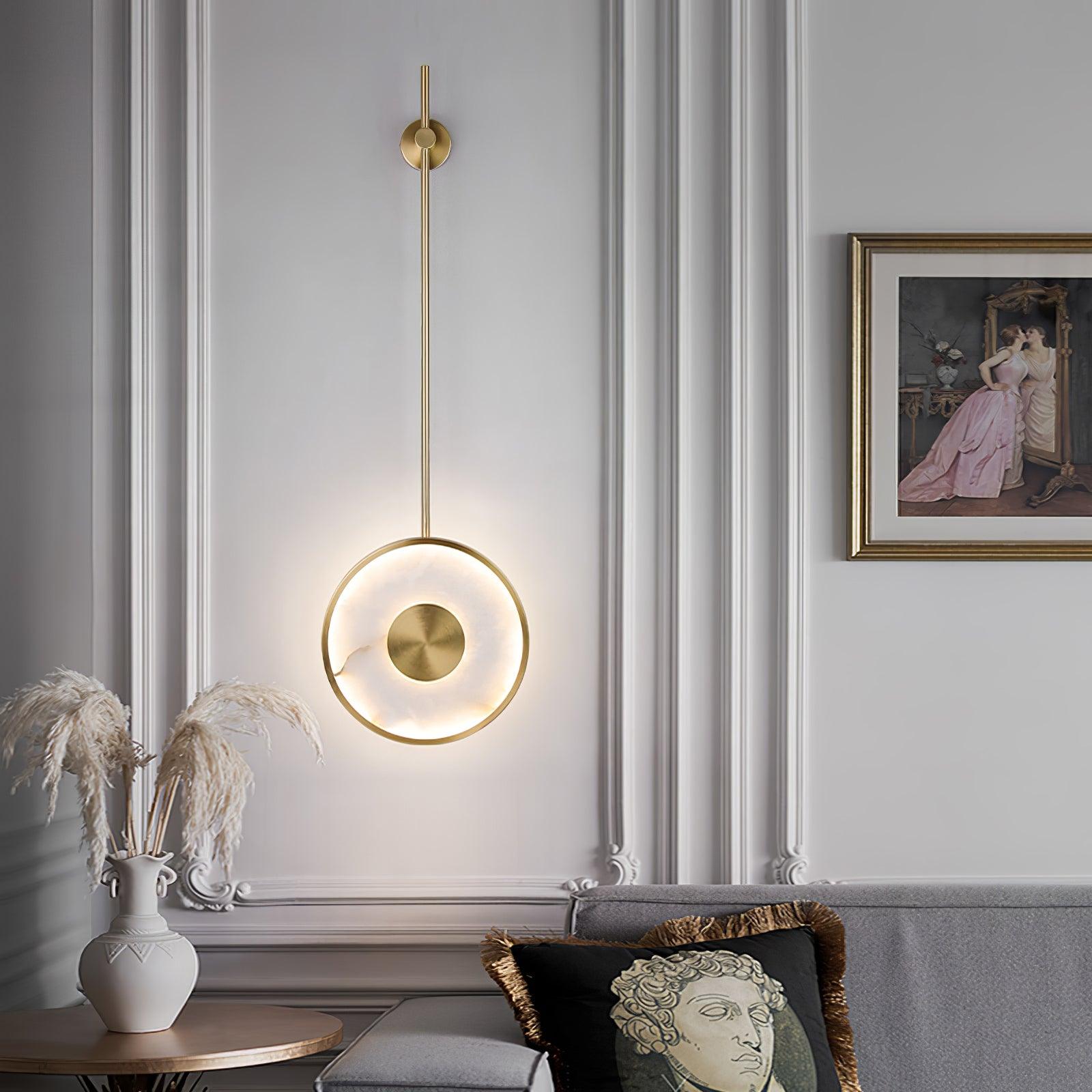 Lit in a classical panelled room beside framed art, pampas grass in a vase below.