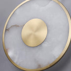 Extreme close-up of the brushed brass boss set into the veined alabaster disc.