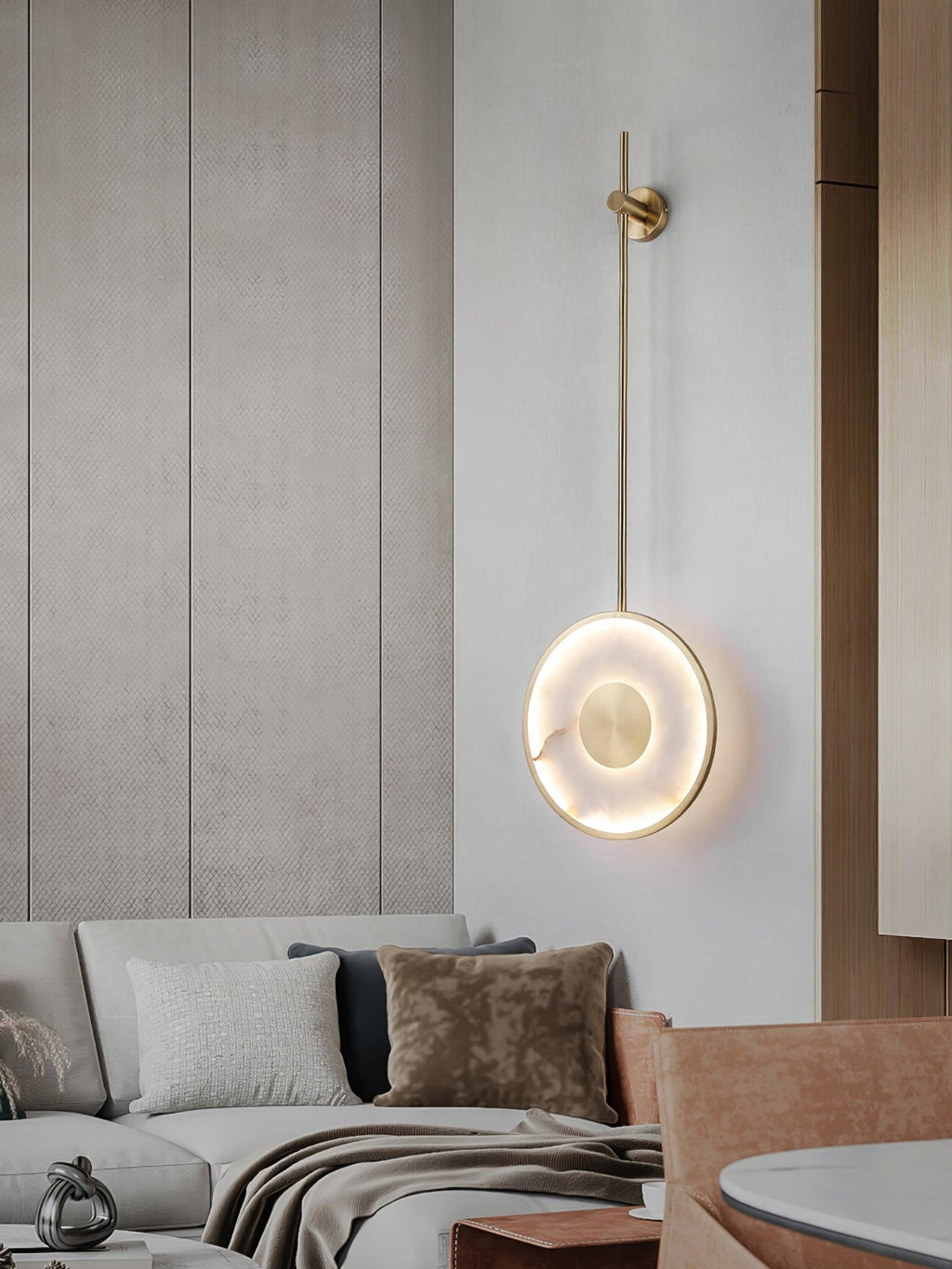 Lit on a pale wall above a cream sofa with a tan cushion and timber cabinetry beyond.
