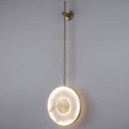 The fixture lit on grey, showing the full rod drop and the halo around the disc.