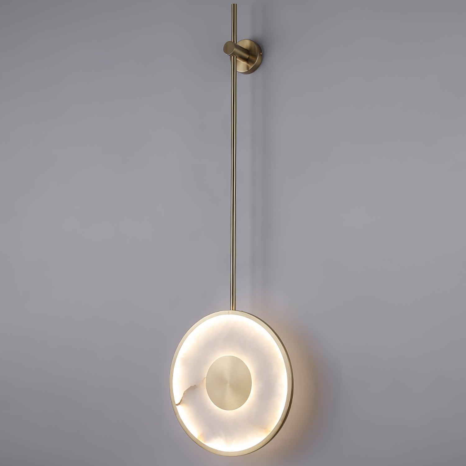 The fixture lit on grey, showing the full rod drop and the halo around the disc.