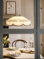 Lit and seen through a window pane, this Clérachic pendant glows above a table set with tulips and glasses.