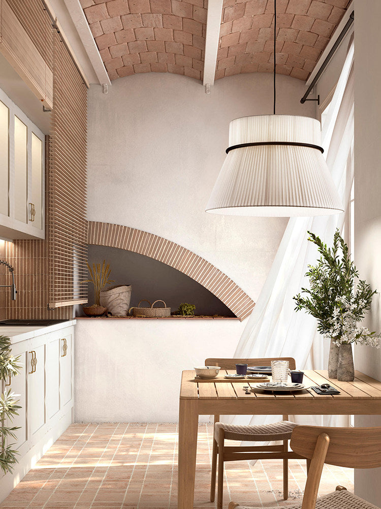 A brick vaulted ceiling and terracotta floor surround a kitchen nook lit by this pleated Clérachic pendant.