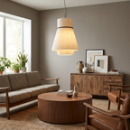 A tweed sofa and round wood coffee table sit beneath this pleated Clérachic pendant in a grey-walled living room.