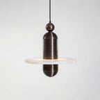 Saturn alabaster pendant light in dark bronze, single stone disc lit from within, side view on grey