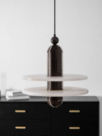 Dark bronze Saturn pendant unlit over a black sideboard, showing the ribbed body and stone veining