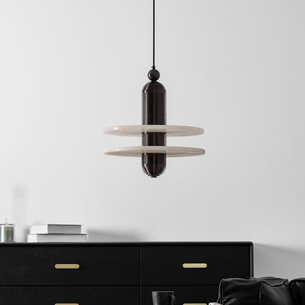 Dark bronze Saturn pendant unlit, its wide alabaster discs framed against a plain white wall