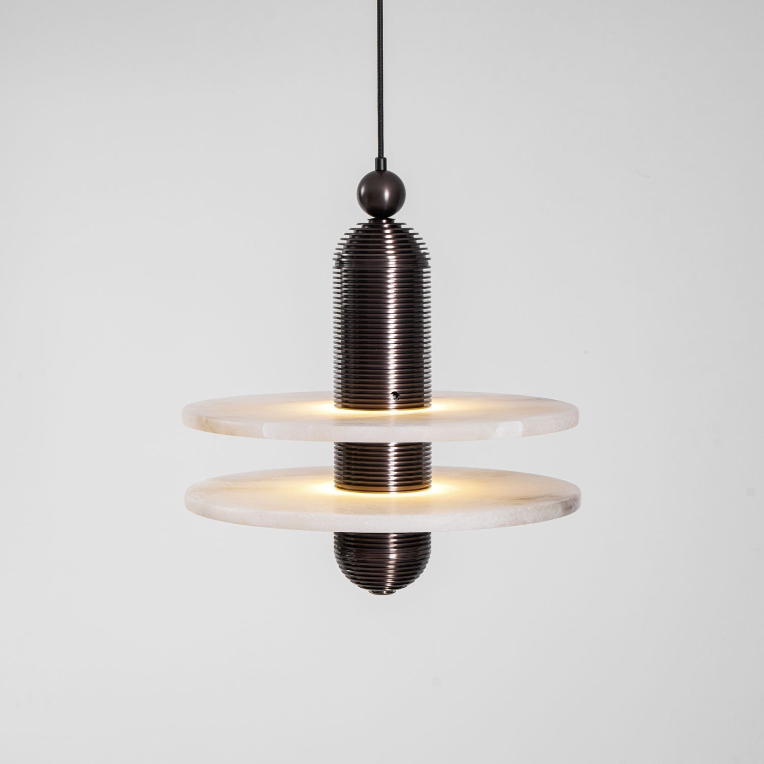 Saturn alabaster pendant light in dark bronze with two stacked stone discs, both edges glowing