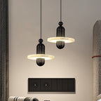 Pair of black Orion pendants lit beside a bedroom wall above a dark switch plate.