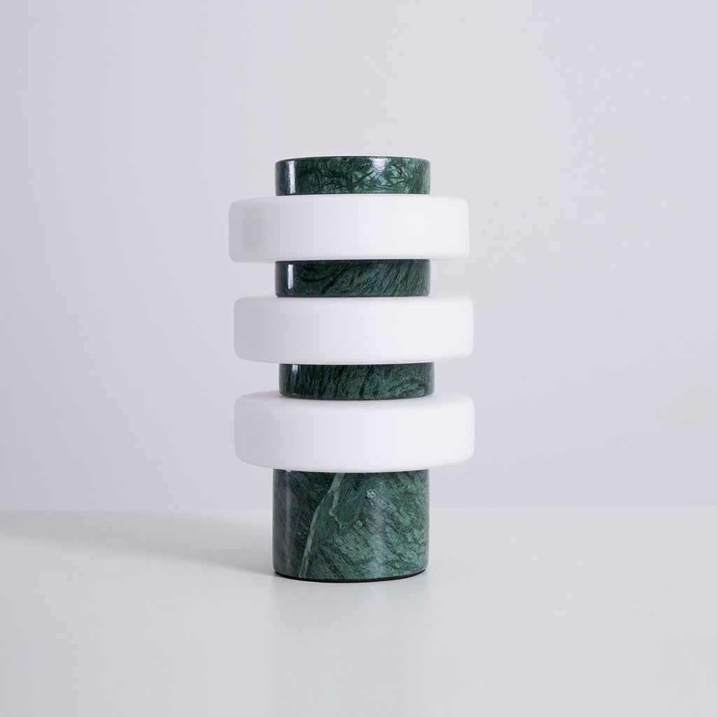 Studio shot of the unlit Clérachic green marble table lamp on a white background, showing its stone rings.