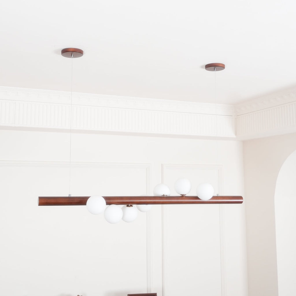 Warm walnut pendant light above a contemporary dining table
