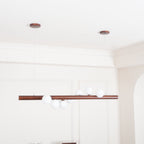 Warm walnut pendant light above a contemporary dining table