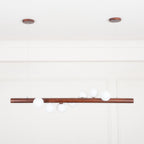 Opal glass globe pendant on walnut bar in a cozy interior