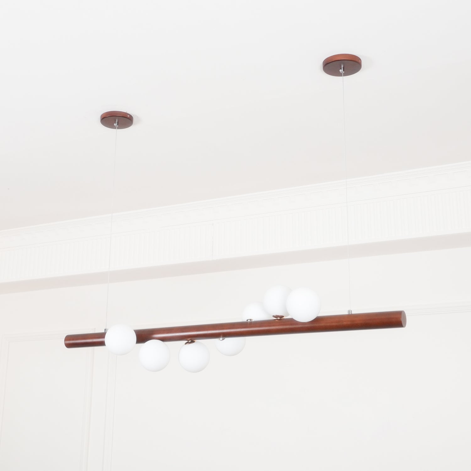 Scandinavian walnut pendant light casting a soft warm glow