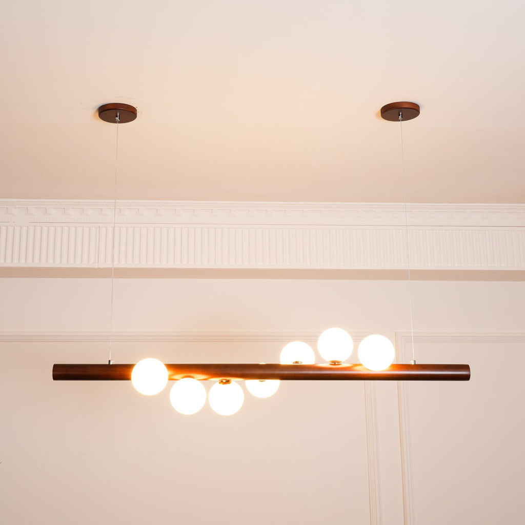 Linear walnut pendant light with soft glowing glass globes