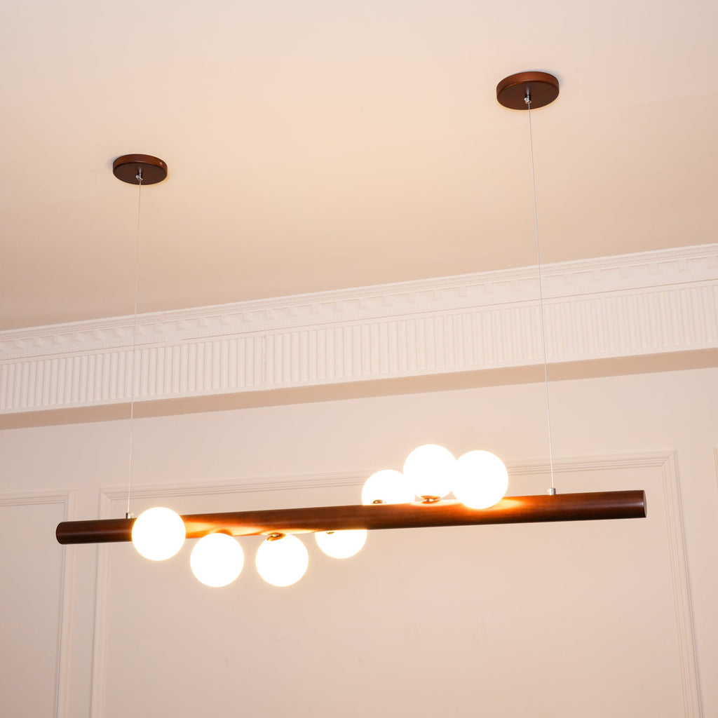 Walnut wood pendant bar with evenly spaced opal glass globes