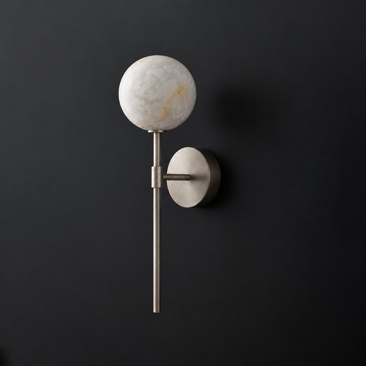 Cutout view of this Clérachic wall sconce in nickel, its rod and ball shade lit against black.