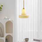 Glass schoolhouse pendant light over a styled table setting