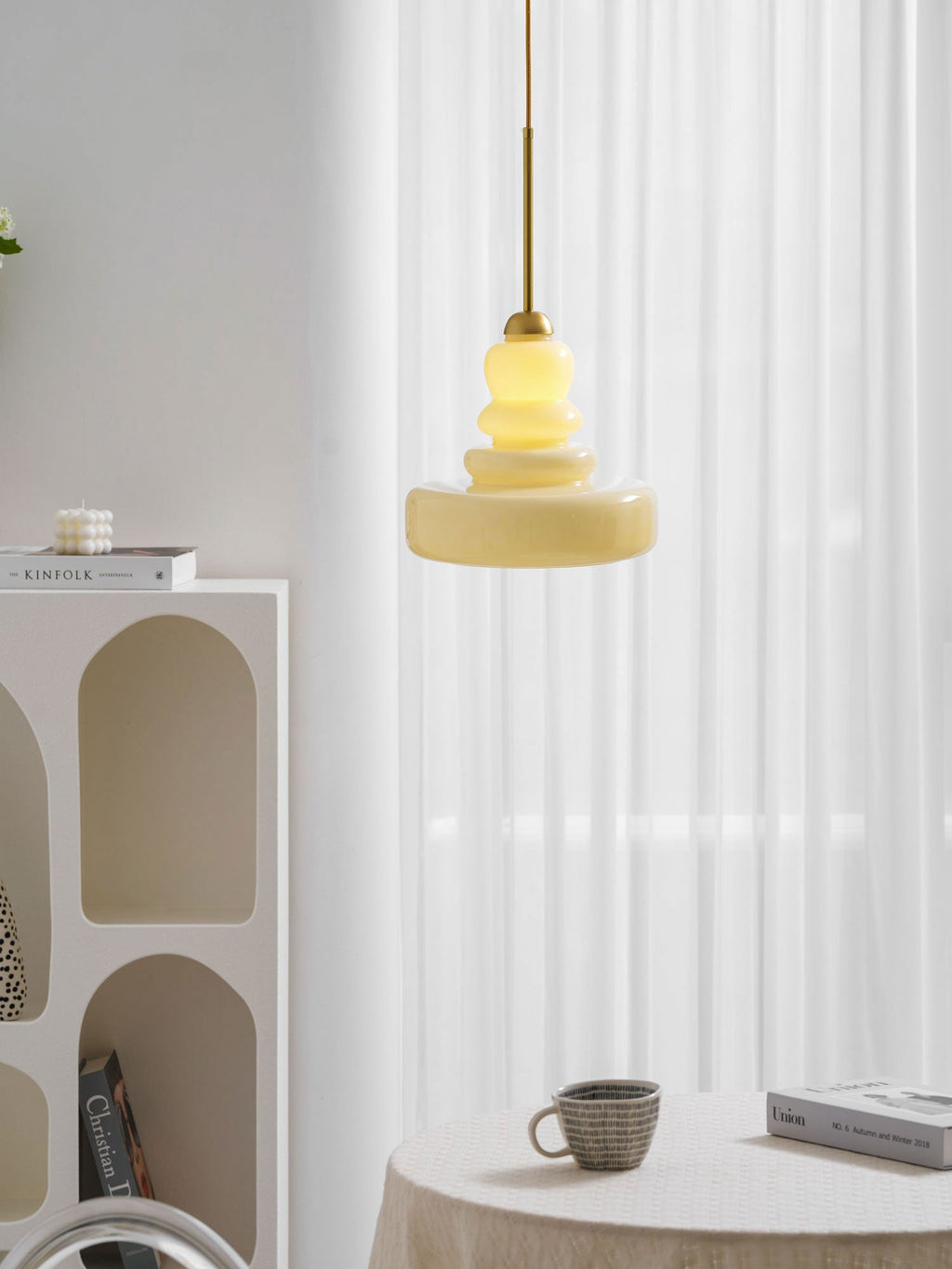Vintage schoolhouse glass pendant glowing in a warm room