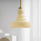 Schoolhouse glass pendant light over a counter at dusk