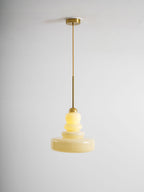 Beige schoolhouse glass pendant glowing over a workspace