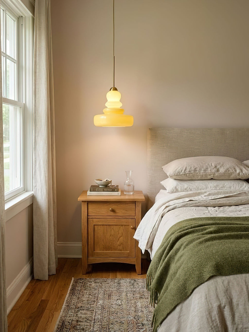 Rounded glass shade of a schoolhouse pendant glowing warmly