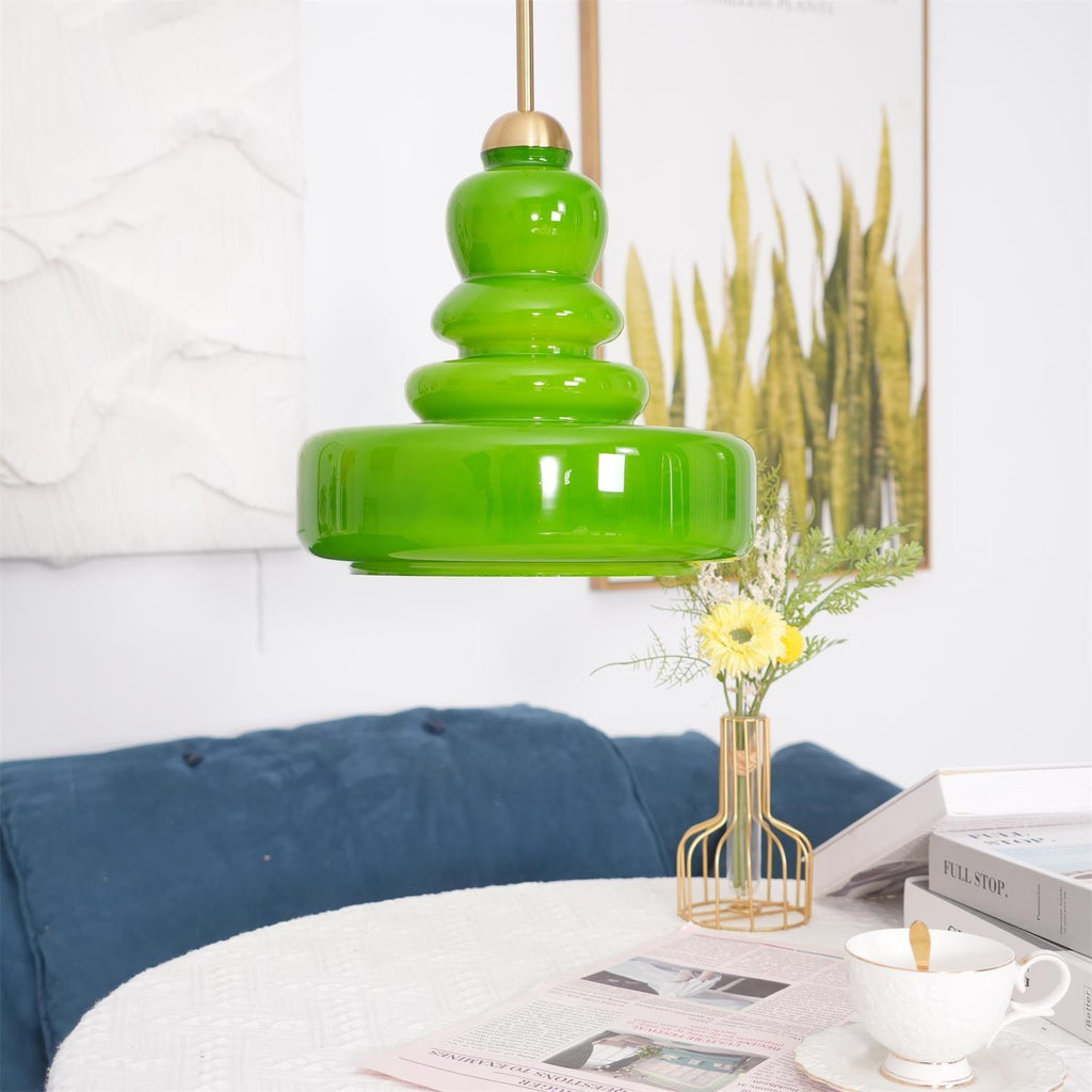 Schoolhouse pendant glass shade glowing against a dark wall